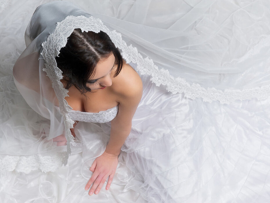 Sitzende Braut mit langem, ausgebreitetem Schleier
