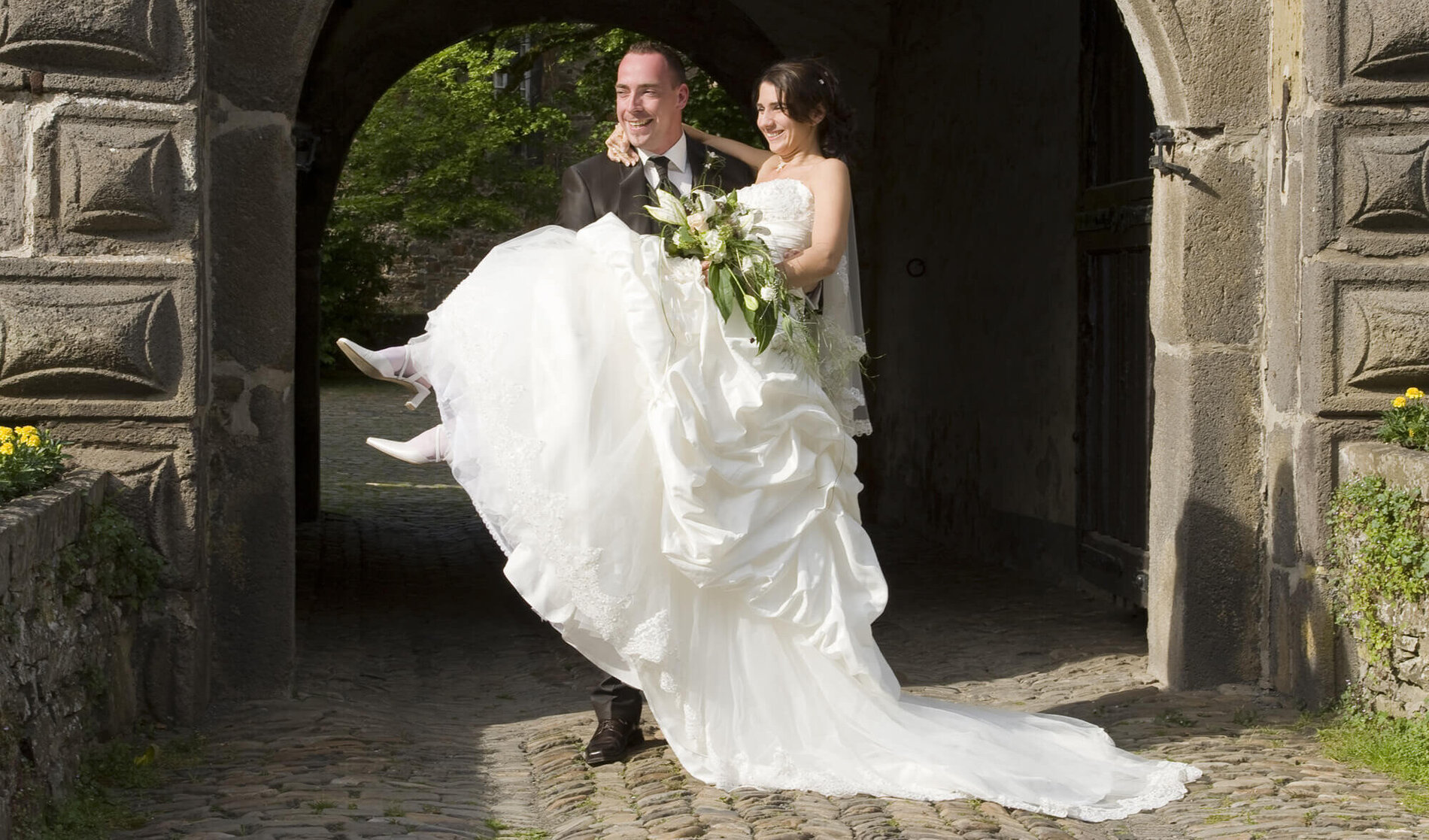 Der Bräutigam trägt die Braut über die Schwelle