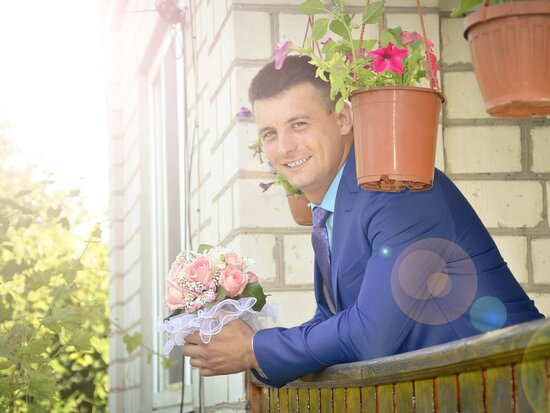 Bräutigam im blauen Anzug mit Blumenstrauß in der Hand