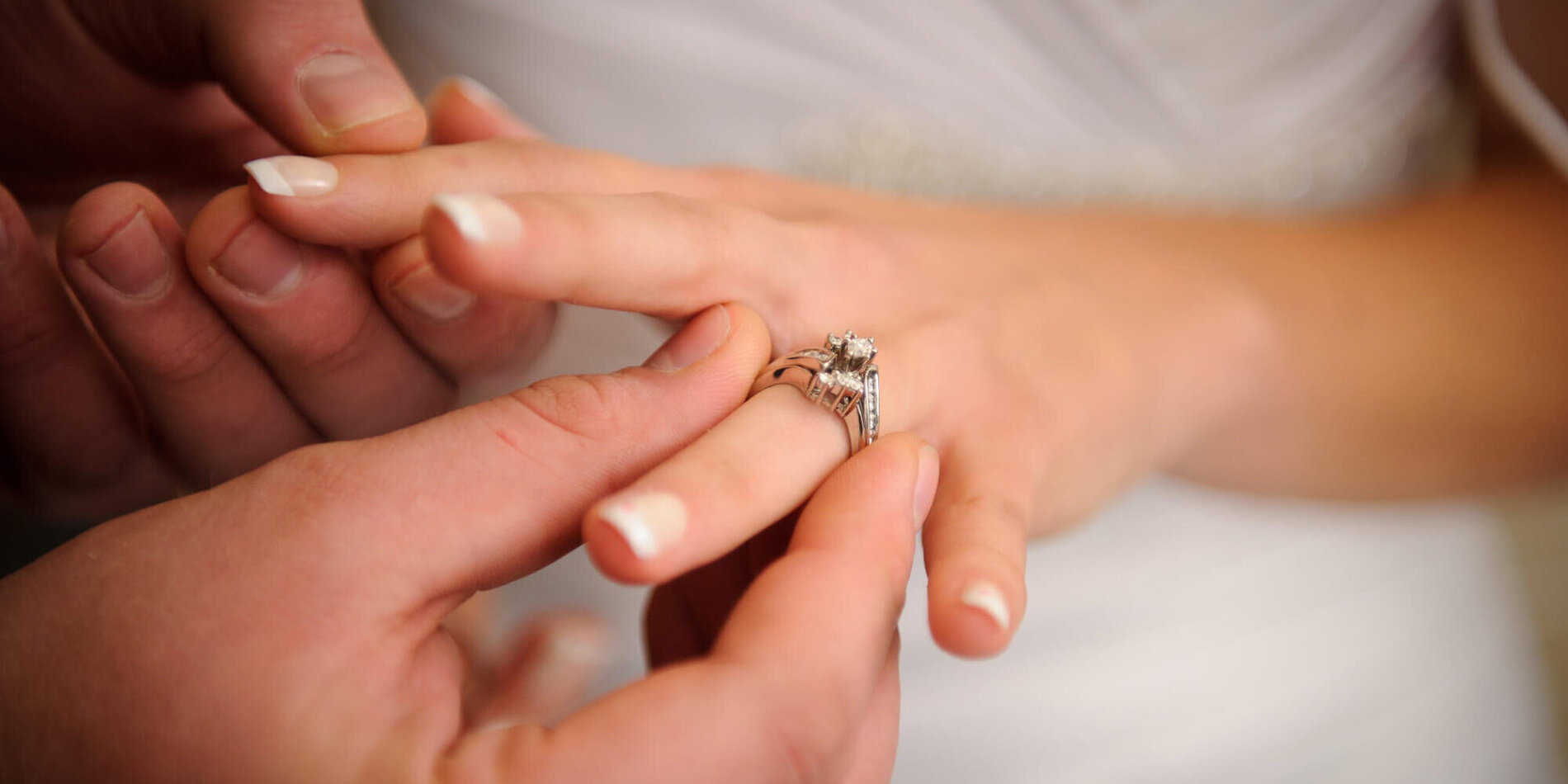 Bräutigam steckt Braut den Ehering an den Finger