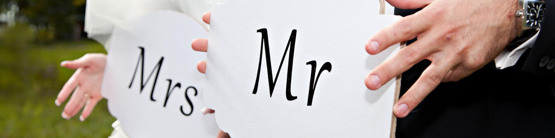 Brautpaar mit Schild mit der Aufschrift MR und MRS