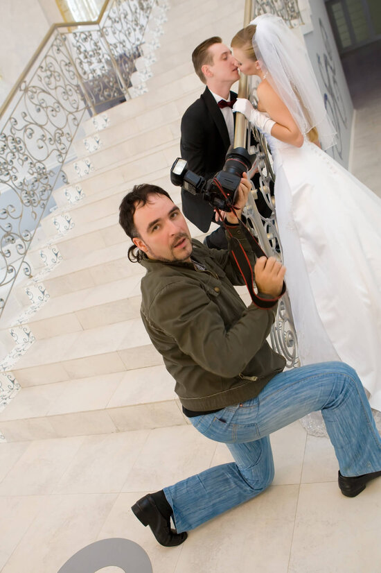 Fotograf schießt Hochzeitsfotos von küssenden Brautpaar