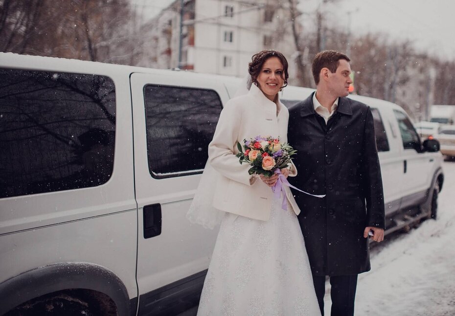 Ein Brautpaar im Winter vor einer Limousine