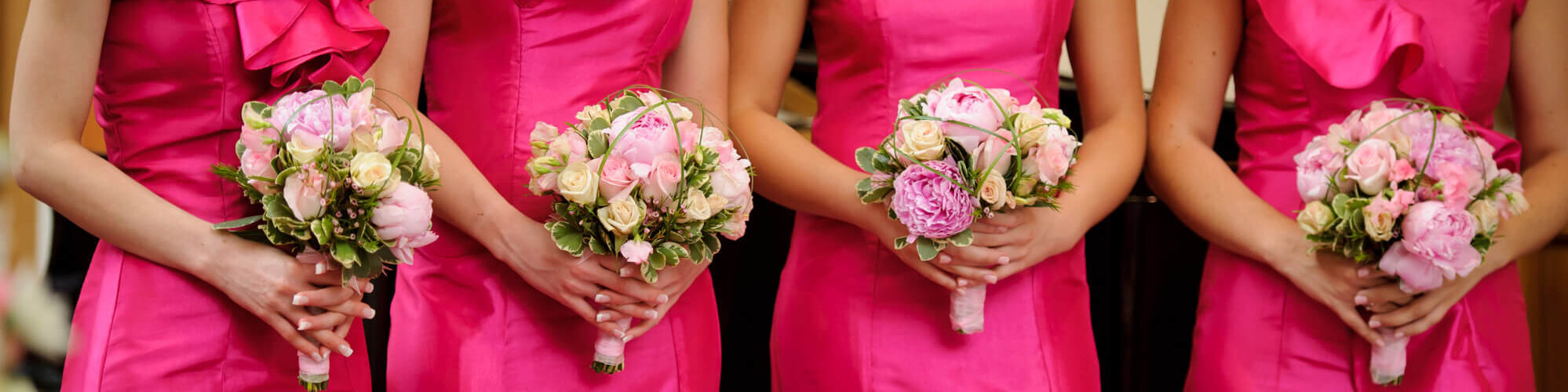 Brautjungfern in pinken Kleidern mit Blumenstrauß