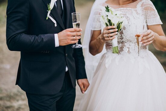Vorbereitung auf die Hochzeitsnacht: Mit diesen Tipps wird sie unvergesslich - Brautpaar mit einem Glas Sekt