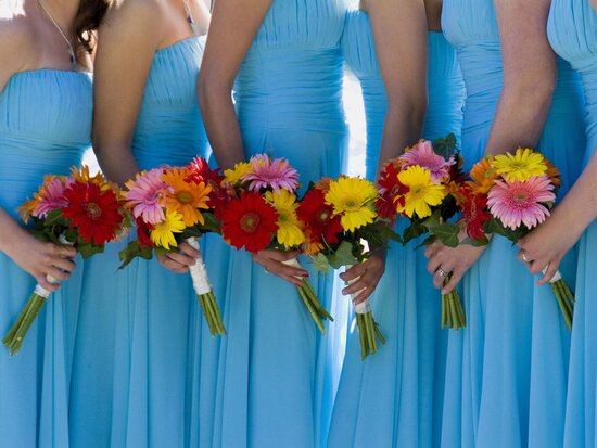 Brautjungfern in blauen Kleidern mit Blumenstrauß