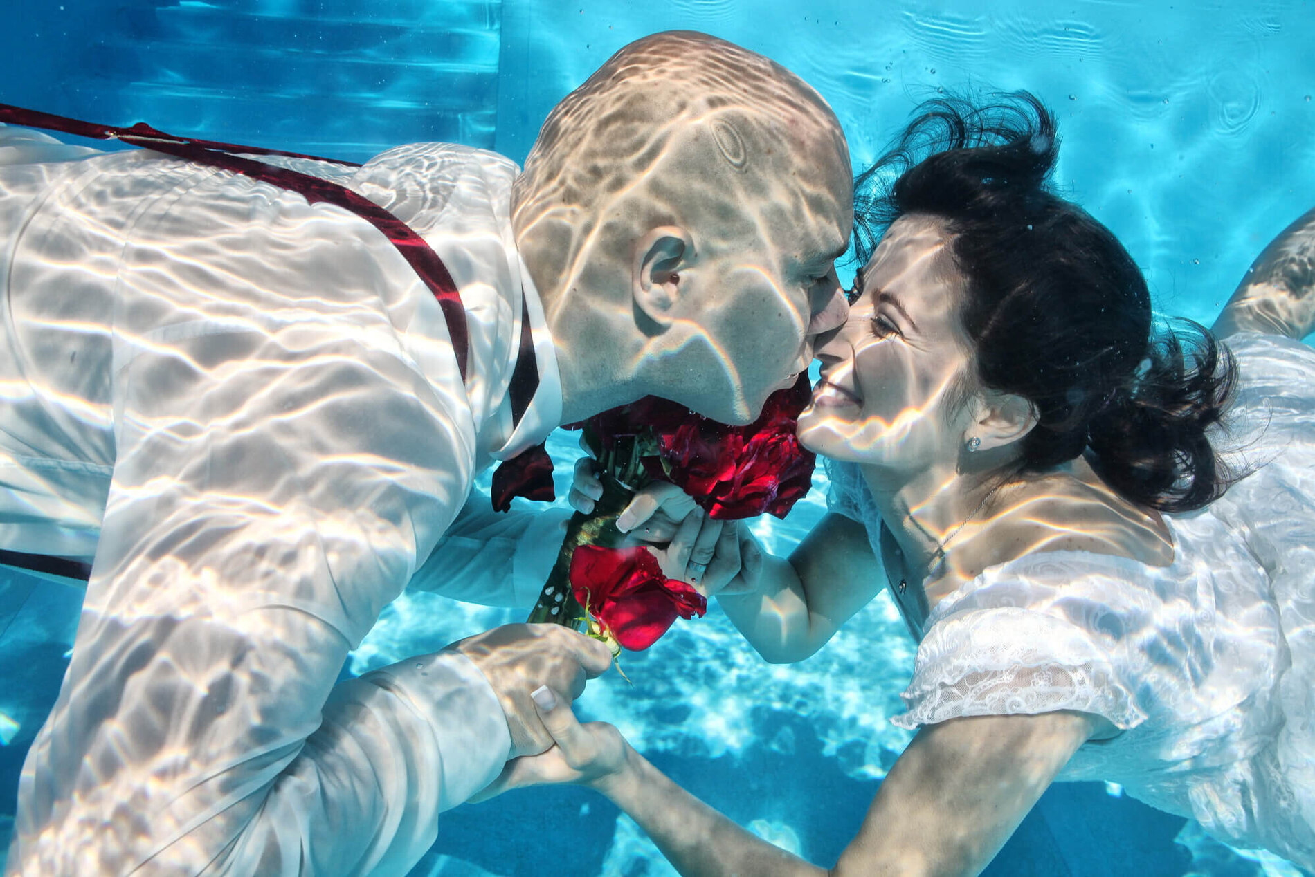 Brautpaar küsst sich unter Wasser